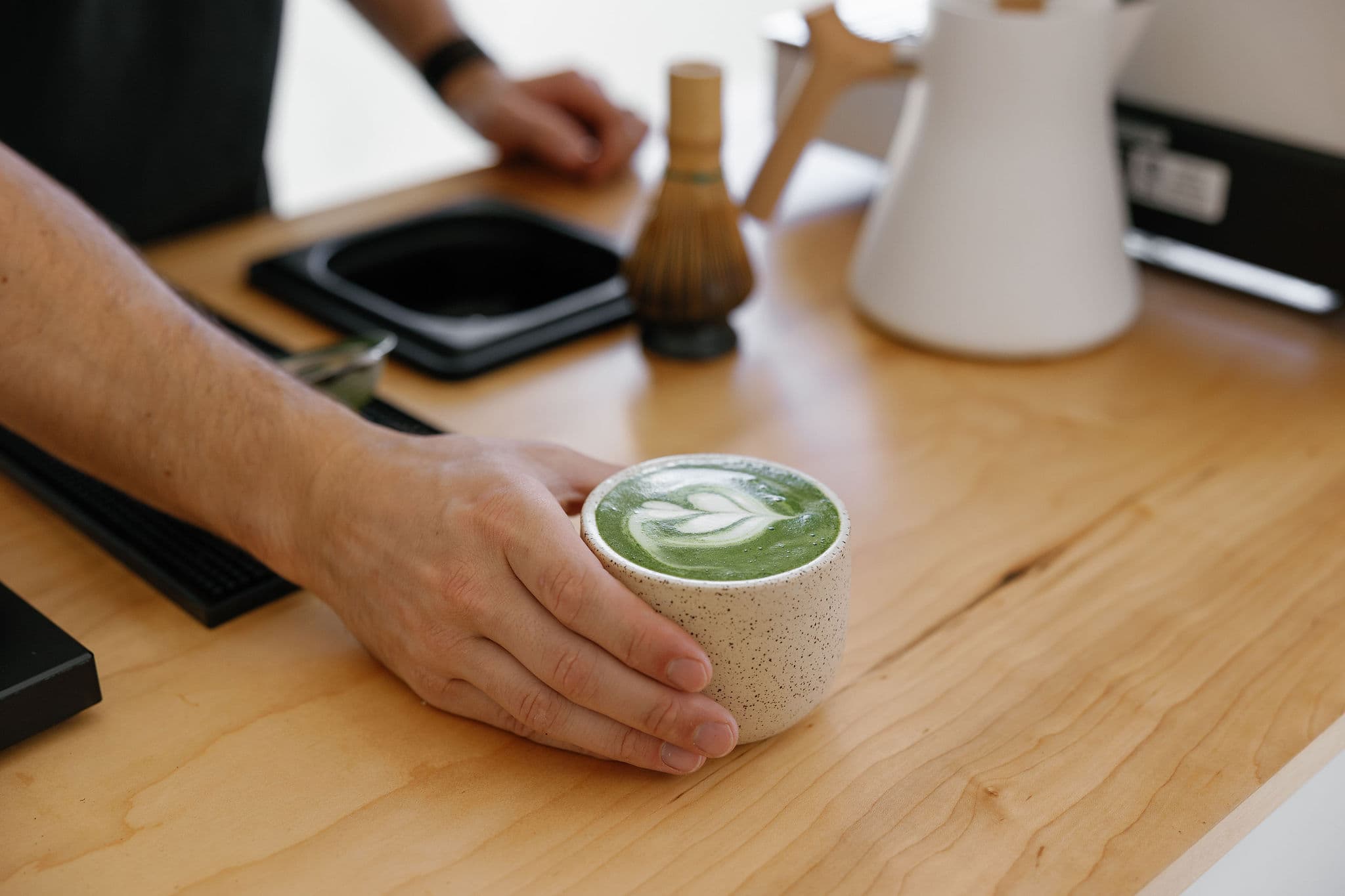 Barista serving matcha latte